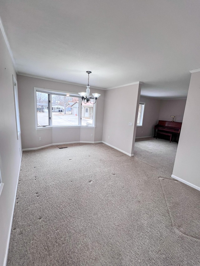 empty room featuring carpet, a chandelier, a wealth of natural light, and ornamental molding