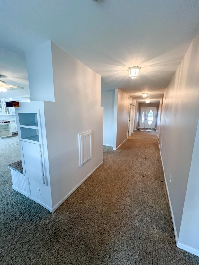 hallway featuring dark colored carpet