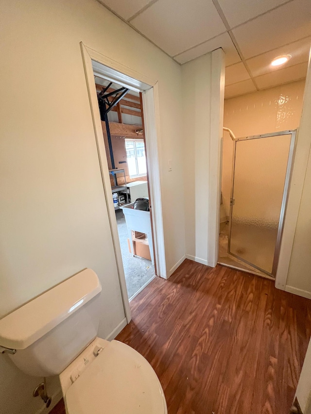 bathroom with a paneled ceiling and wood-type flooring