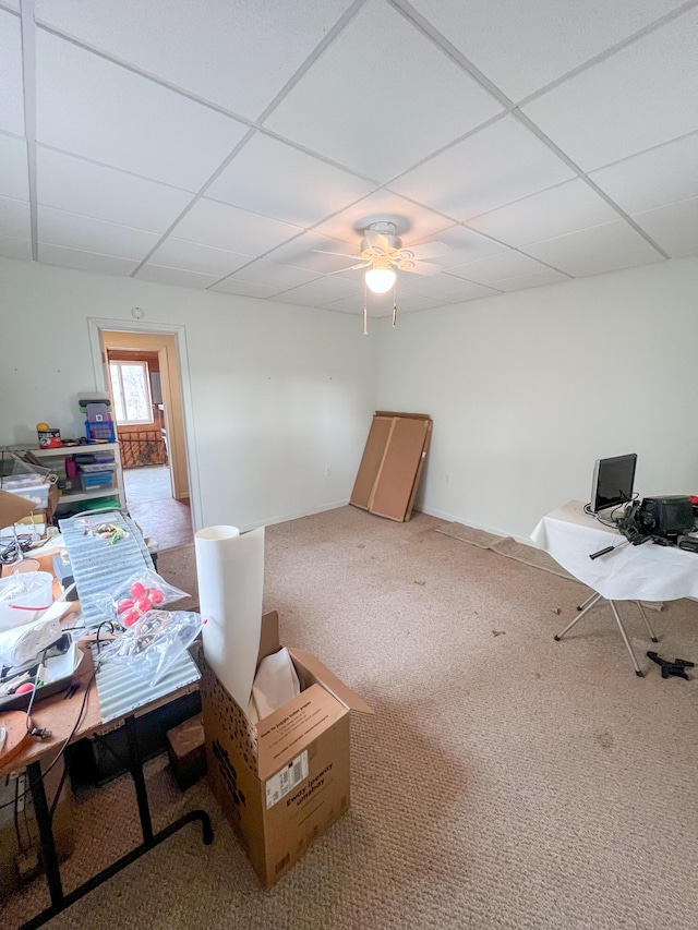 home office with carpet, ceiling fan, and a drop ceiling