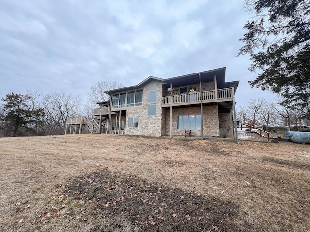 back of property with a deck and a sunroom