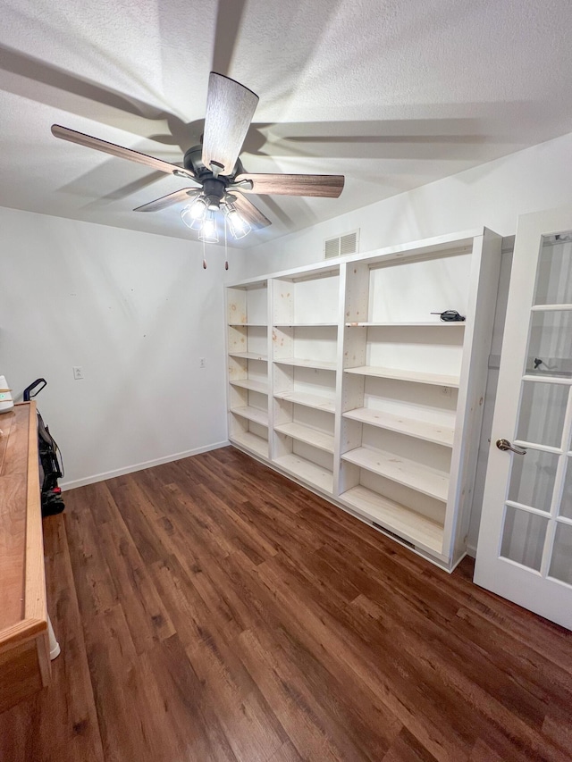 interior space featuring a textured ceiling, ceiling fan, and dark hardwood / wood-style flooring