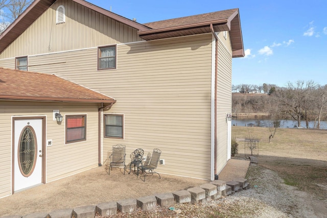 rear view of house with a water view and a patio area