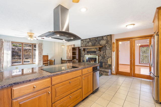 kitchen featuring island exhaust hood, light tile patterned flooring, black electric stovetop, stainless steel refrigerator, and french doors