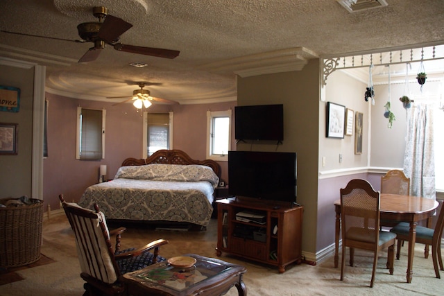 bedroom featuring light colored carpet, visible vents, crown molding, and a textured ceiling