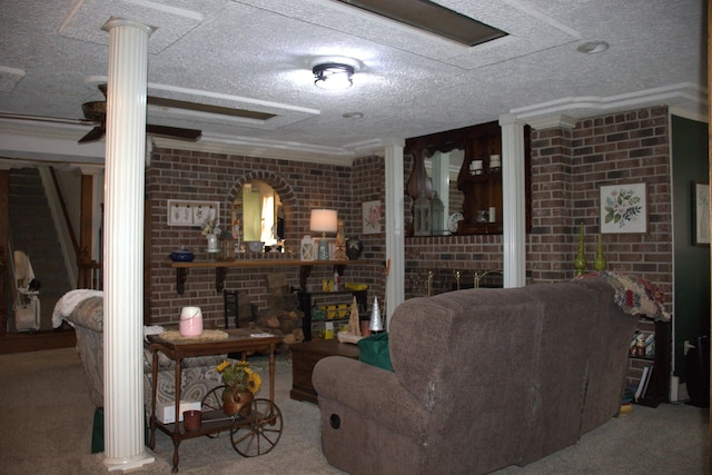 carpeted living area featuring a textured ceiling, brick wall, crown molding, and ornate columns