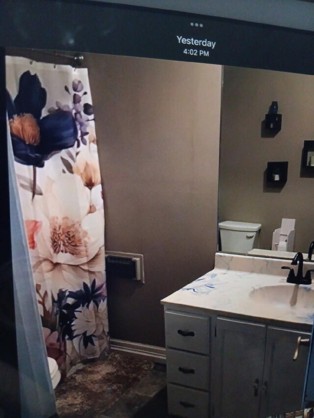 full bathroom featuring baseboards, vanity, and toilet