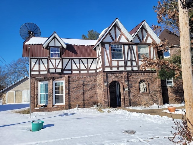 english style home featuring brick siding