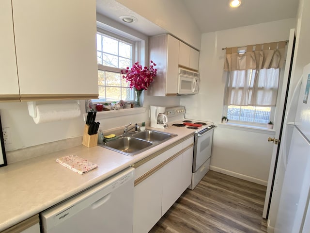 kitchen with sink, white appliances, white cabinets, and dark wood-type flooring