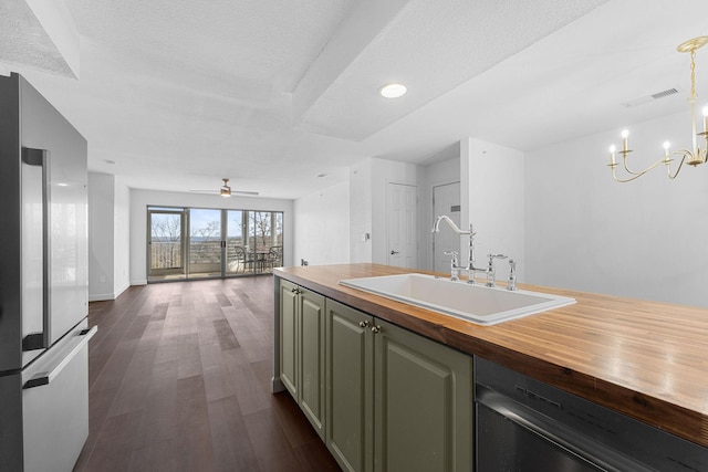 kitchen with high quality fridge, sink, dishwasher, wooden counters, and pendant lighting