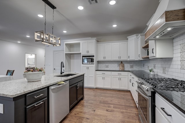 kitchen with white cabinets, appliances with stainless steel finishes, sink, and custom exhaust hood