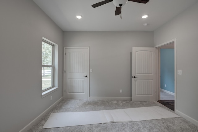 unfurnished bedroom with ceiling fan and light colored carpet