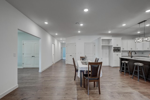 dining area with light hardwood / wood-style floors and sink