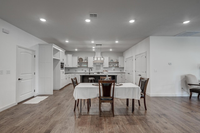 dining space featuring light wood-type flooring and sink