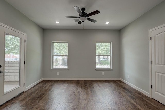 empty room with dark hardwood / wood-style flooring, ceiling fan, and a wealth of natural light