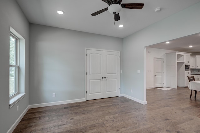 empty room with ceiling fan and light wood-type flooring