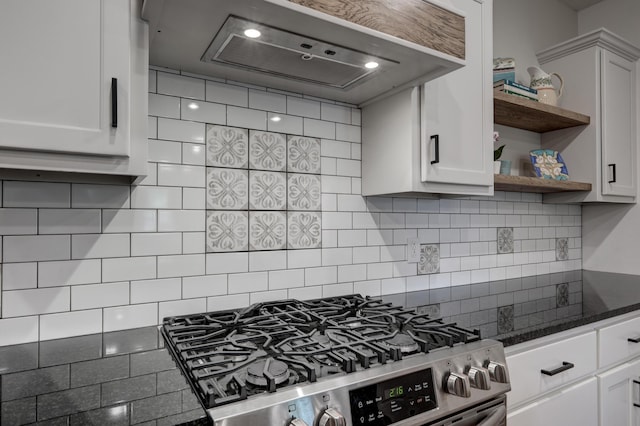 kitchen with backsplash, stainless steel gas stove, white cabinets, and custom exhaust hood