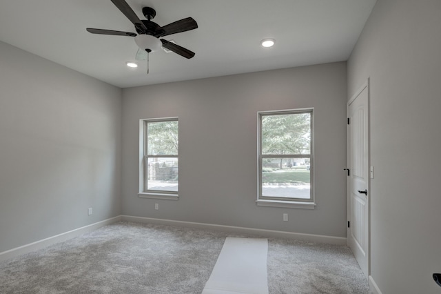 spare room with light colored carpet and ceiling fan