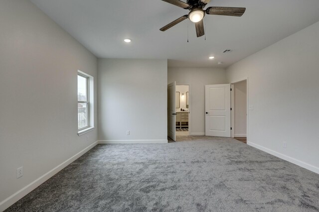 unfurnished bedroom with carpet flooring, ceiling fan, and ensuite bath