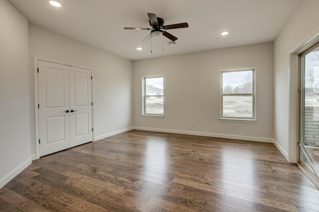 unfurnished room with ceiling fan and dark wood-type flooring