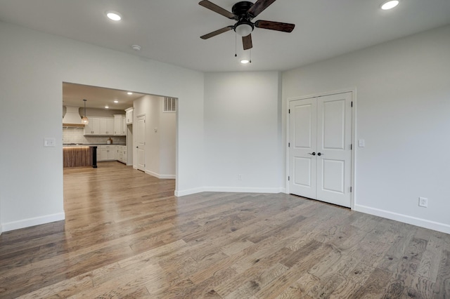 unfurnished living room with ceiling fan and light hardwood / wood-style floors