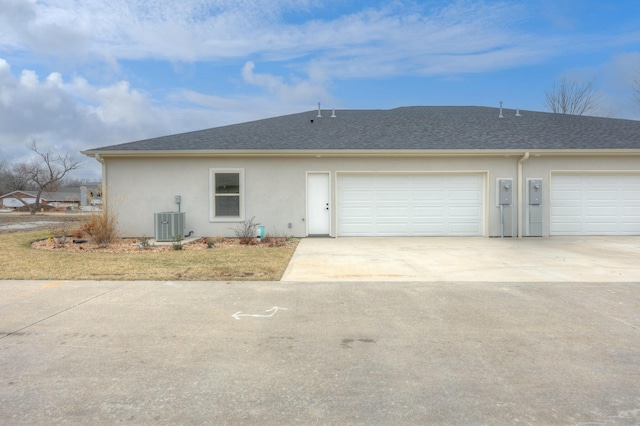 view of front of home featuring central air condition unit and a garage