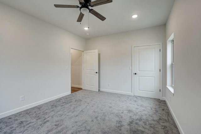 unfurnished bedroom featuring dark carpet and ceiling fan