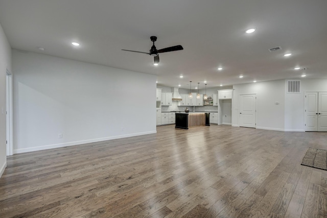 unfurnished living room featuring hardwood / wood-style floors and ceiling fan