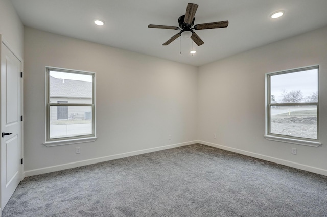 carpeted spare room featuring ceiling fan