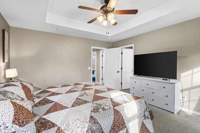 bedroom with a tray ceiling, carpet floors, and ceiling fan