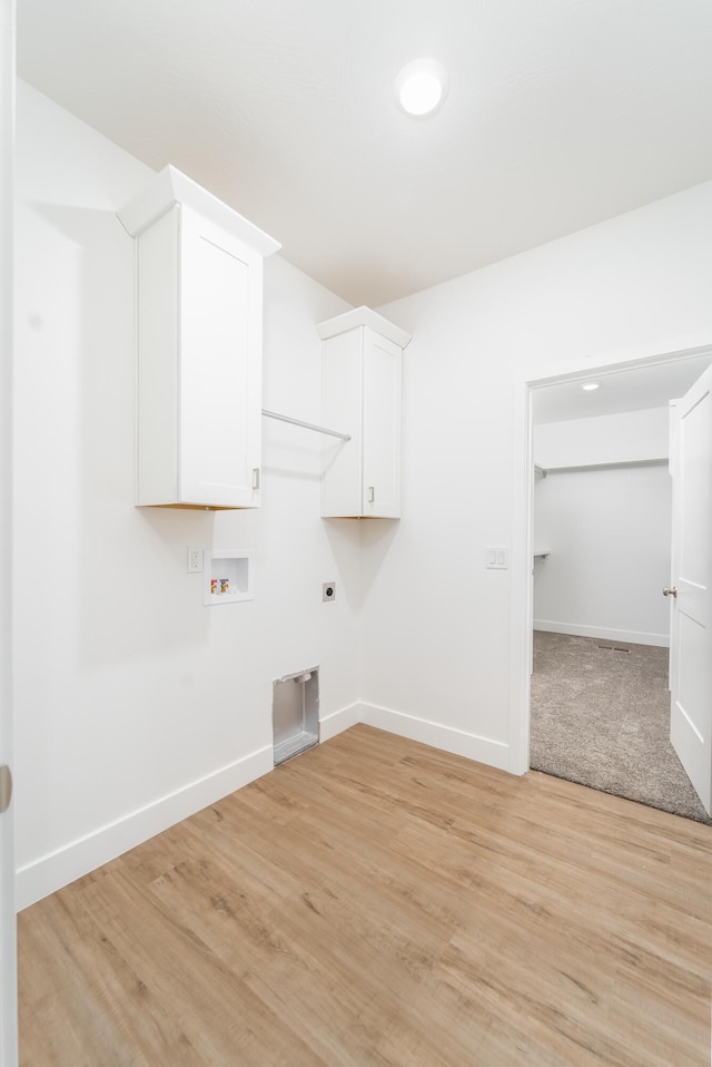 laundry room with cabinets, light hardwood / wood-style floors, hookup for a washing machine, and electric dryer hookup