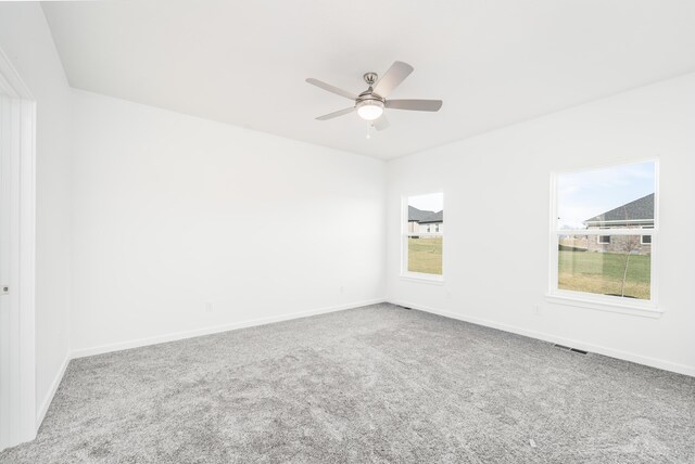 unfurnished room with ceiling fan and carpet