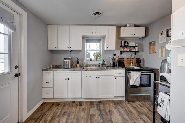 kitchen with visible vents, white cabinets, dark wood-style floors, stainless steel electric range, and a sink