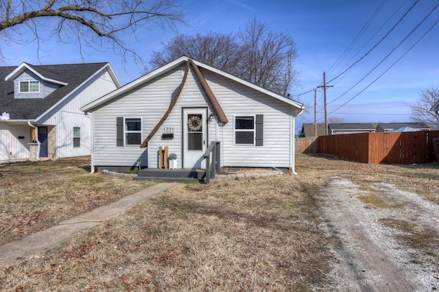 bungalow featuring driveway and fence