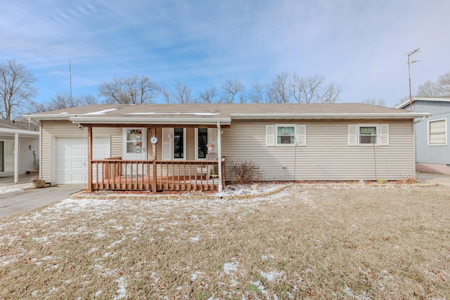 ranch-style house featuring a porch, an attached garage, and aphalt driveway