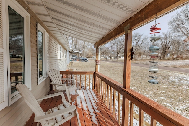 snow covered deck featuring a porch