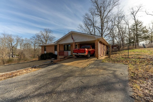 ranch-style house featuring aphalt driveway, brick siding, and a carport