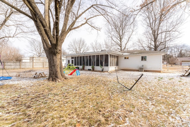 rear view of property featuring central AC, a chimney, fence, and a sunroom