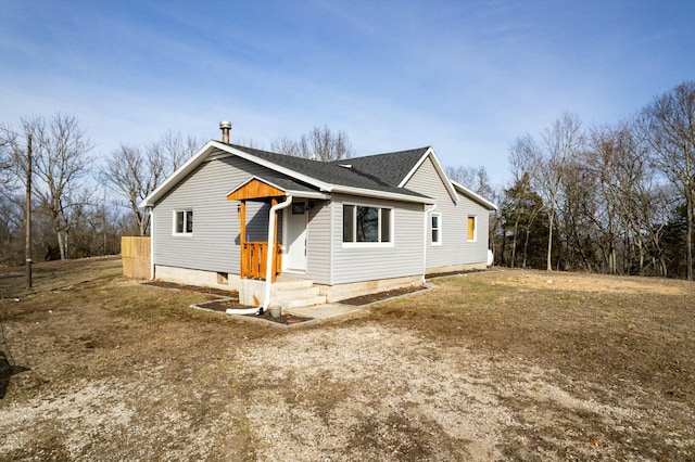 view of front of home with a front lawn and roof with shingles