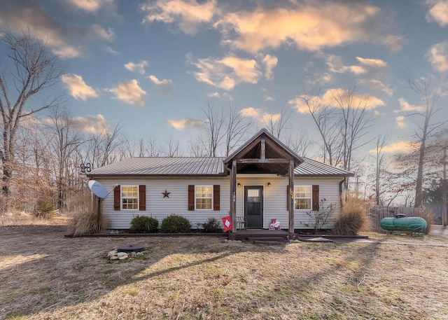 view of front of home with metal roof and a lawn