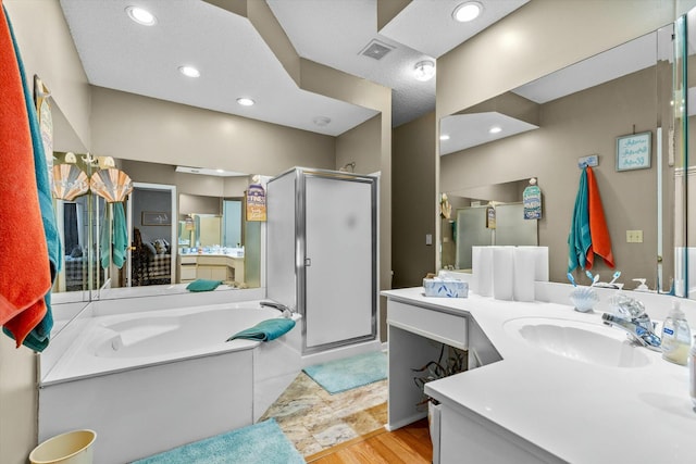 full bath with a garden tub, visible vents, a shower stall, vanity, and wood finished floors