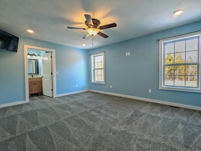 unfurnished bedroom featuring dark colored carpet, recessed lighting, and baseboards