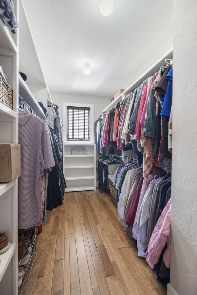 walk in closet with wood finished floors