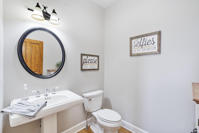 half bathroom with toilet and baseboards