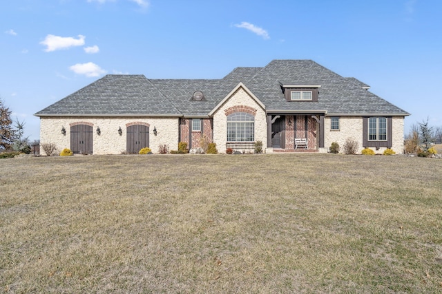 french country style house featuring a front lawn and brick siding