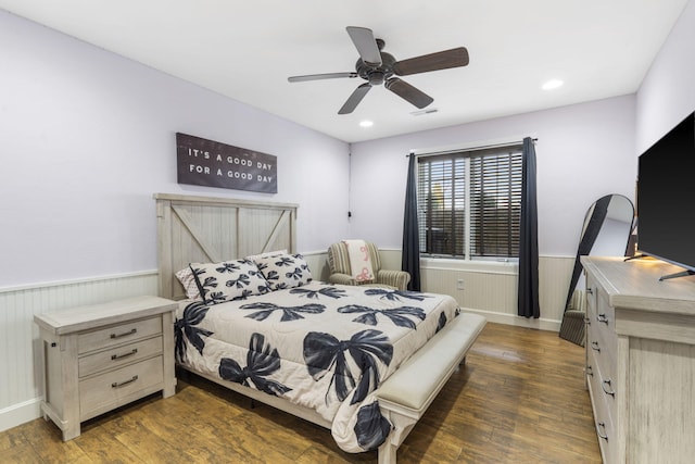 bedroom with dark wood-type flooring, recessed lighting, wainscoting, and visible vents