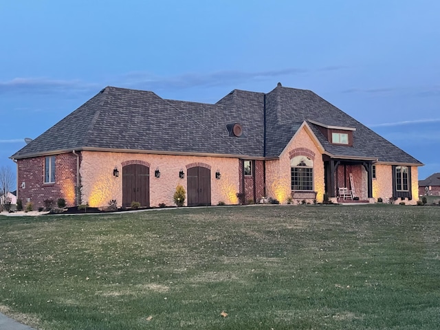 french country style house with a front lawn and brick siding