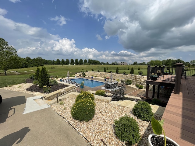 pool featuring a patio area and a rural view