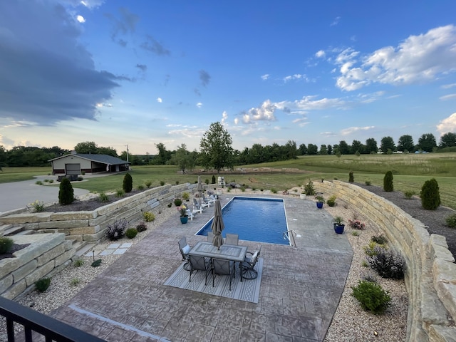 view of pool featuring a fenced in pool, a patio area, and a lawn