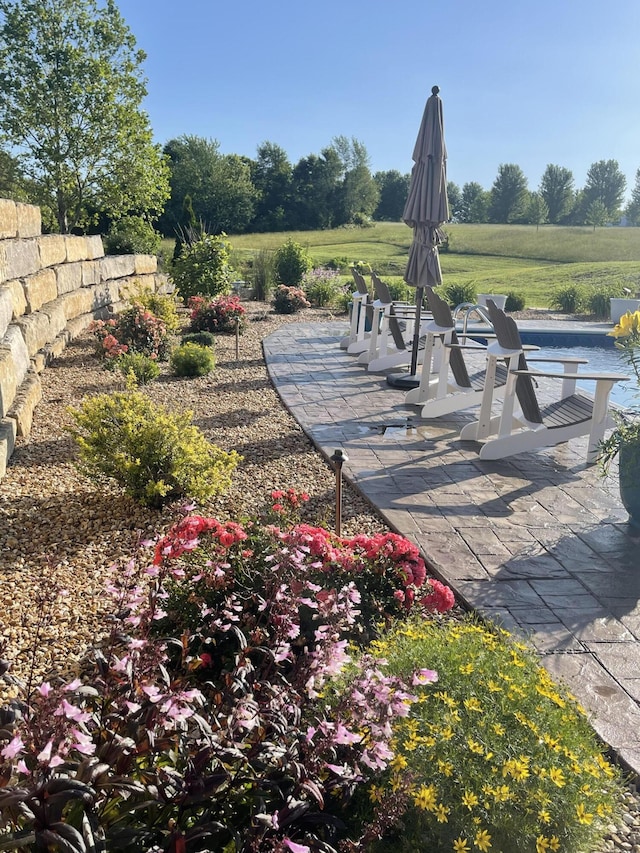 view of community featuring a rural view and a patio area